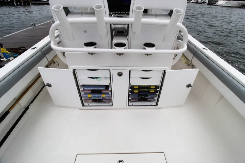 Slide: The Image of 2020 Regulator 28 Forward Seating boat with open storage compartments and rod holders. - 19