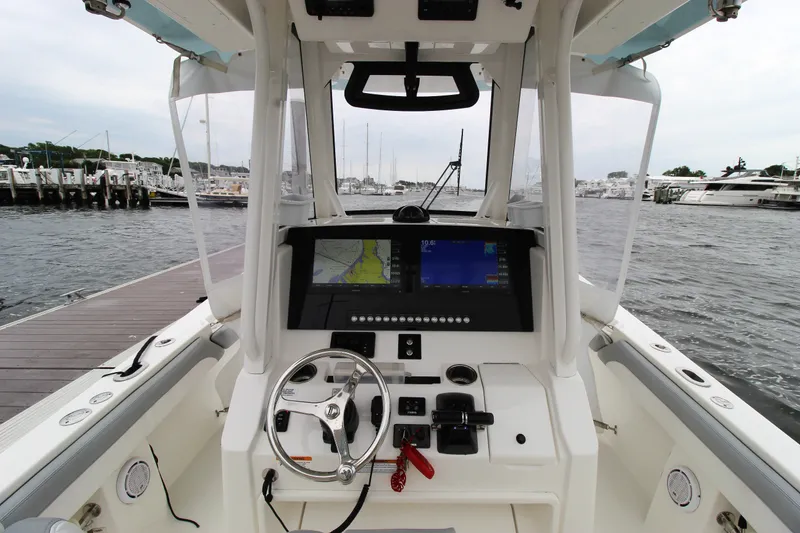 Slide: The Image of 2020 Regulator 28 Forward Seating boat cockpit with navigation system at marina. - 18