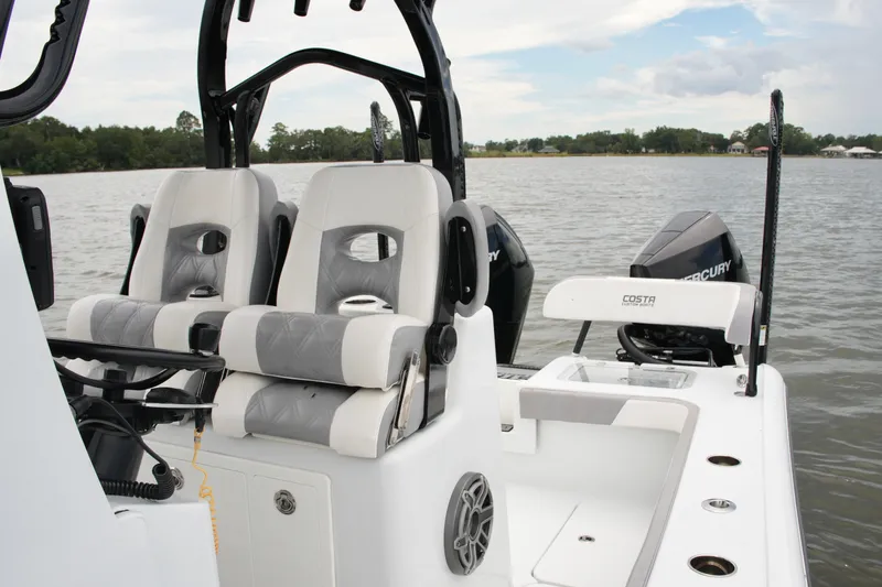 Slide: The Image of 2023 Costa Custom Boats 264 HC interior with dual seats and Mercury engines on a lake. - 39