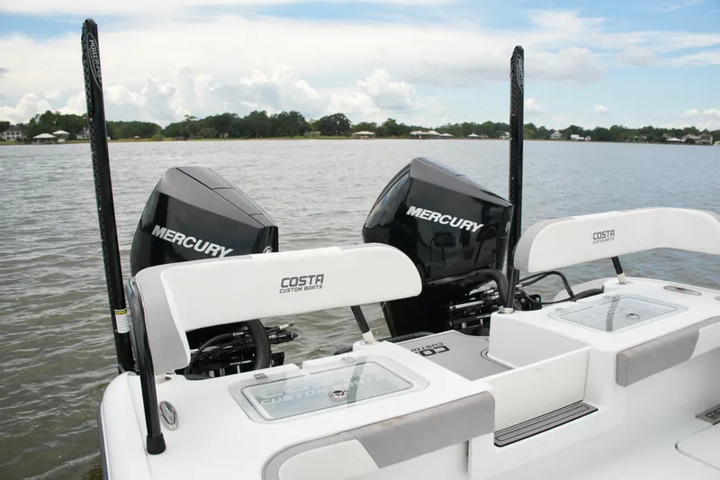 Slide: The Image of 2023 Costa Custom Boats 264 HC with dual Mercury engines on a calm lake. - 55