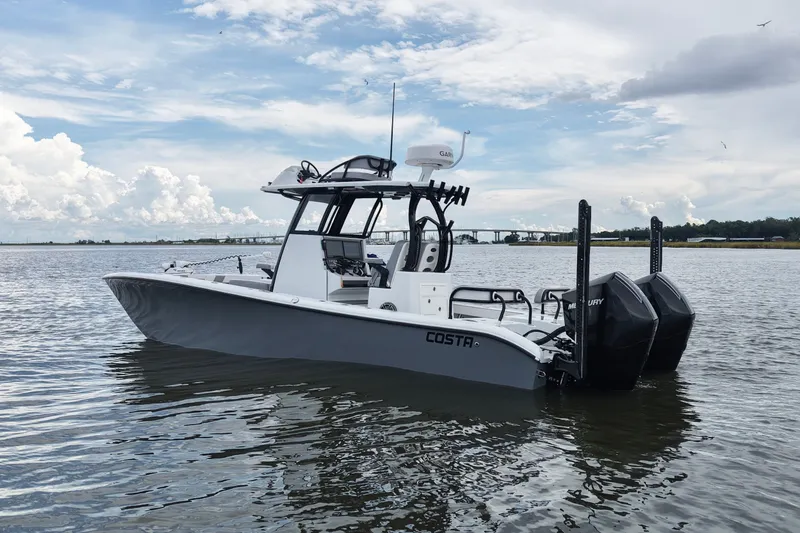 Slide: The Image of 2023 Costa Custom Boats 264 HC on calm water under a cloudy sky. - 16