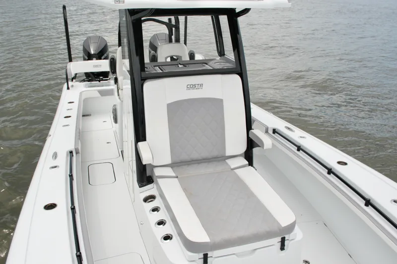 Slide: The Image of 2023 Costa Custom Boats 264 HC, sleek design, luxury seating, on calm water. - 32
