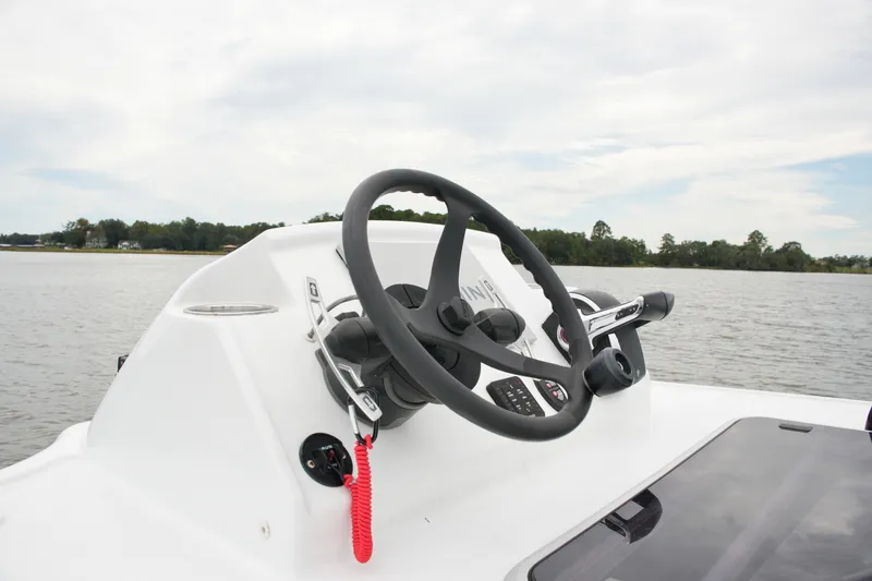 Slide: The Image of Steering console of 2023 Costa Custom Boats 264 HC on a calm lake. - 64