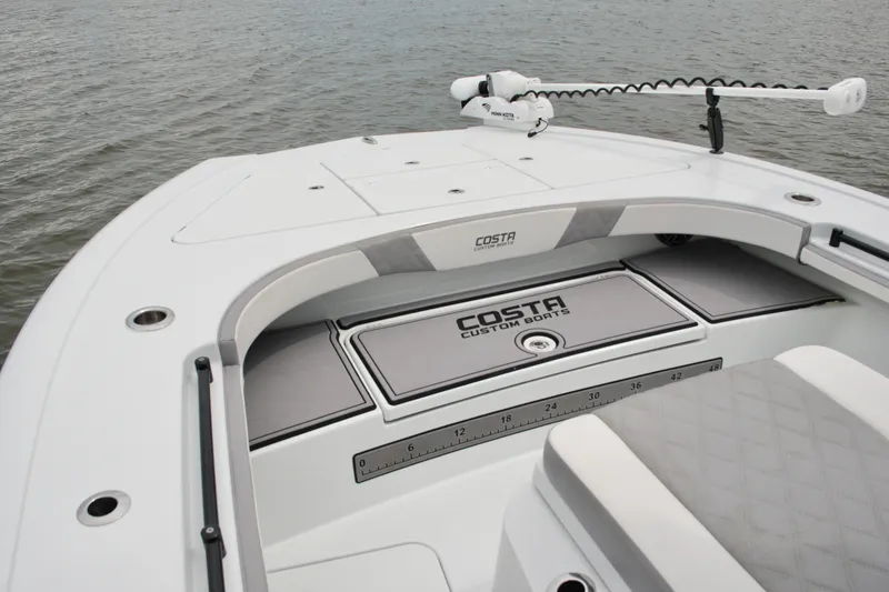 Slide: The Image of 2023 Costa Custom Boats 264 HC bow with storage compartments on calm water. - 29