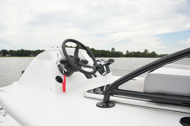 Slide: The Image of 2023 Costa Custom Boats 264 HC steering console on a calm lake. - 62