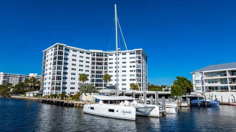 Slide: The Image of 2018 Lagoon 42 catamaran aangemeerd bij waterkant gebouw. - 4