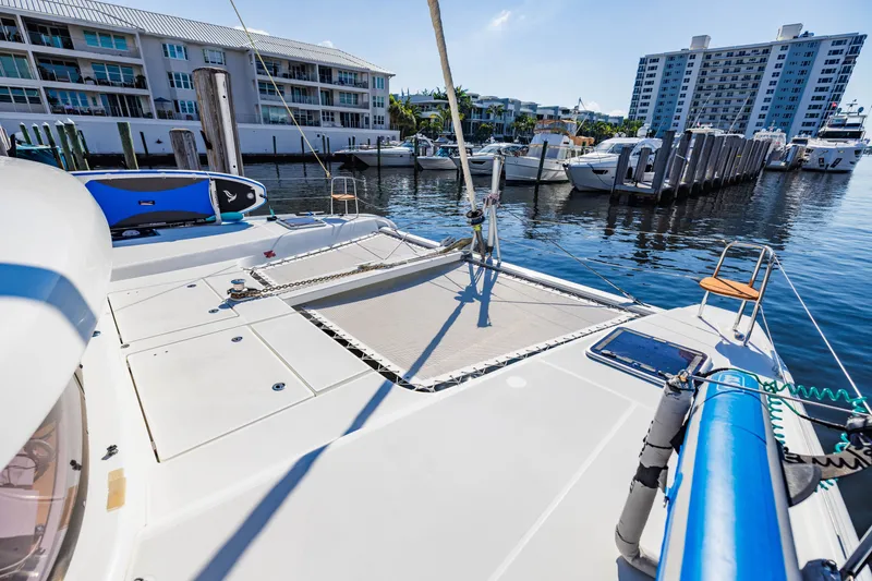 Slide: The Image of 2018 Lagoon 42 catamaran aangemeerd met moderne gebouwen op de achtergrond. - 43