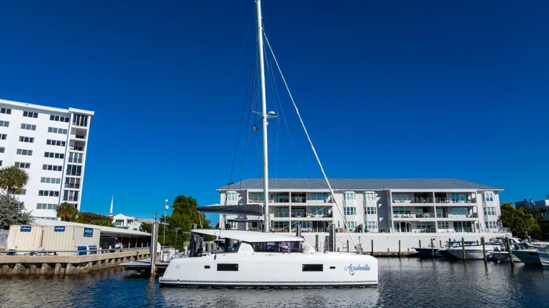 Slide: The Image of Lagoon 42 Katamaran 2018 im Hafen vor modernen Gebäuden. - 46
