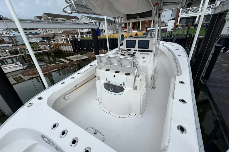 Slide: The Image of 2007 Cape Horn 24OS boat docked, featuring a spacious deck and dual console setup. - 21