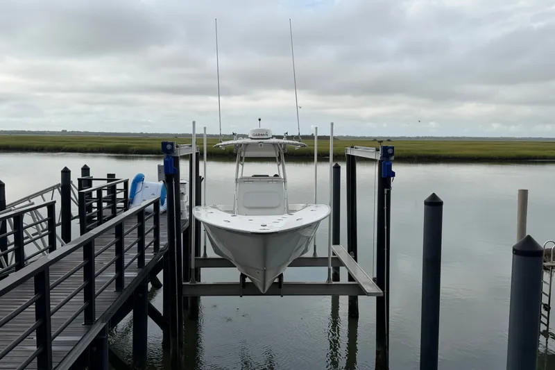 Slide: The Image of 2007 Cape Horn 24OS boat on lift at dockside, calm water background. - 24