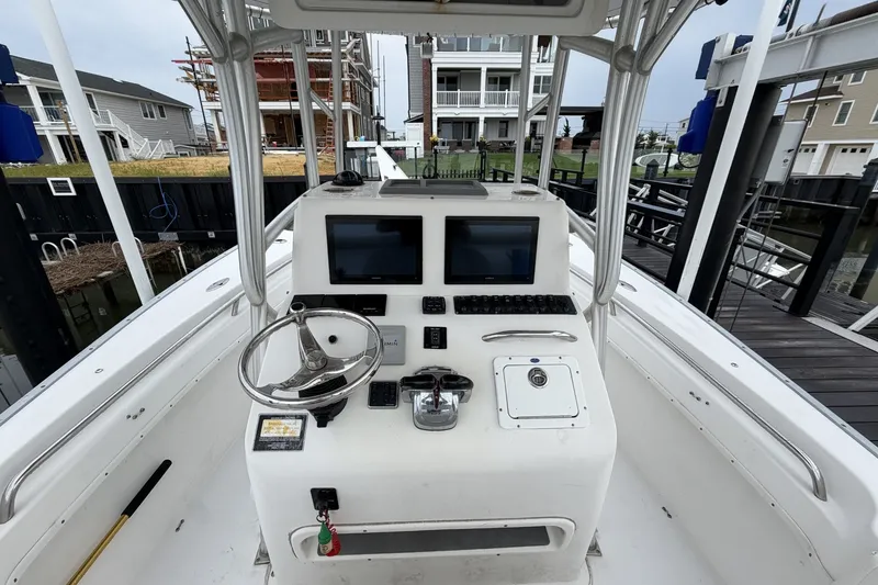 Slide: The Image of 2007 Cape Horn 24OS boat console with dual screens and steering wheel at dock. - 16