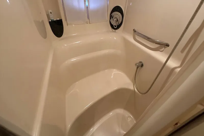 Slide: The Image of Shower area in 2003 Sea Ray 420 Sundancer yacht, featuring a handheld showerhead and grab bar. - 13