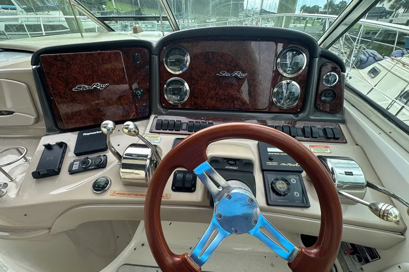 Slide: The Image of Helm of 2003 Sea Ray 420 Sundancer with wood accents and navigation controls. - 20