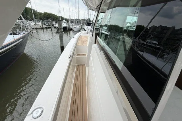 Slide: The Image of 2024 Tiara Yachts 48 LS docked, showcasing sleek deck design and marina view. - 16