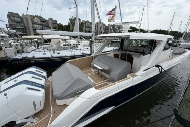 Slide: The Image of 2024 Tiara Yachts 48 LS luxury boat docked, featuring sleek design and powerful engines. - 1