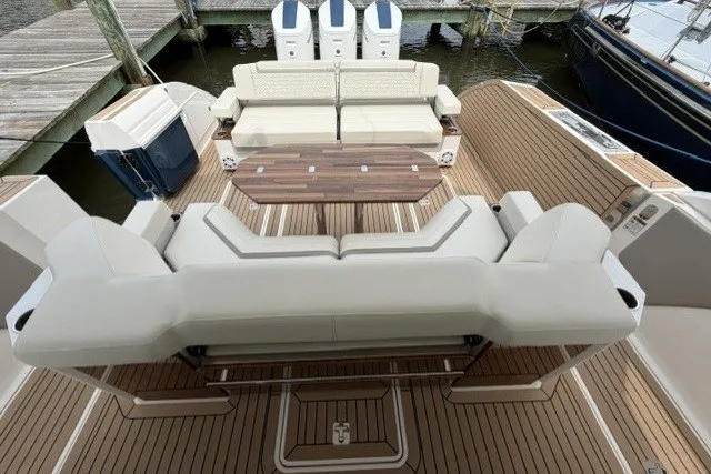 Slide: The Image of 2024 Tiara Yachts 48 LS luxury deck with seating and table, docked at marina. - 6