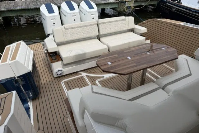 Slide: The Image of Luxurious 2024 Tiara Yachts 48 LS deck with seating and table, featuring triple outboard engines. - 5