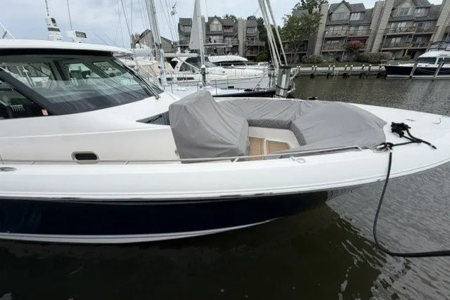 Slide: The Image of 2024 Tiara Yachts 48 LS docked, featuring sleek design and covered seating area. - 4