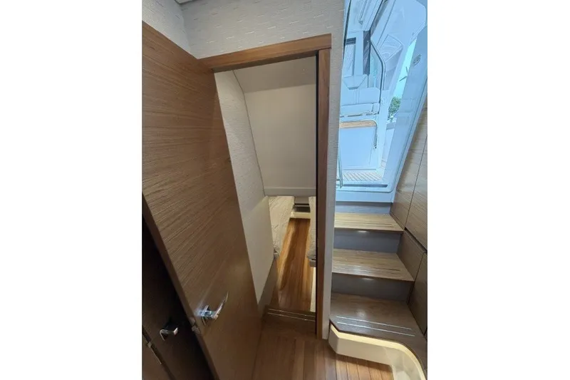 Slide: The Image of Interior view of 2024 Tiara Yachts 48 LS, featuring wooden stairs and modern design. - 24