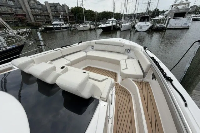Slide: The Image of 2024 Tiara Yachts 48 LS with spacious seating, docked in a marina. - 18