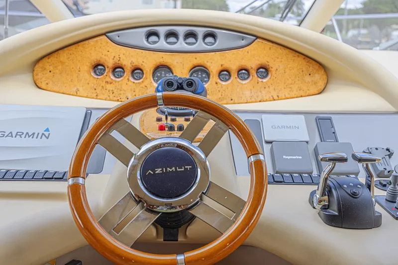 Slide: The Image of Cockpit of 2008 Azimut 62 yacht with wooden steering wheel and navigation controls. - 32