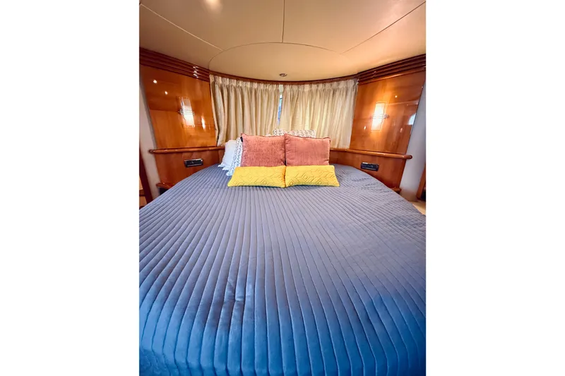 Slide: The Image of Luxurious bedroom interior of 2008 Azimut 62 yacht with elegant bedding and wood paneling. - 54