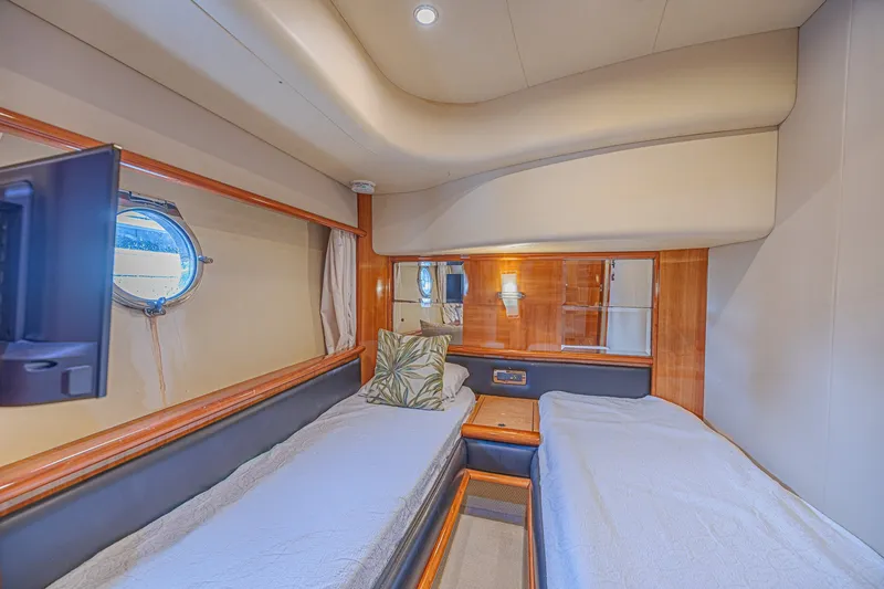 Slide: The Image of Luxurious 2008 Azimut 62 yacht cabin with twin beds and porthole window. - 49