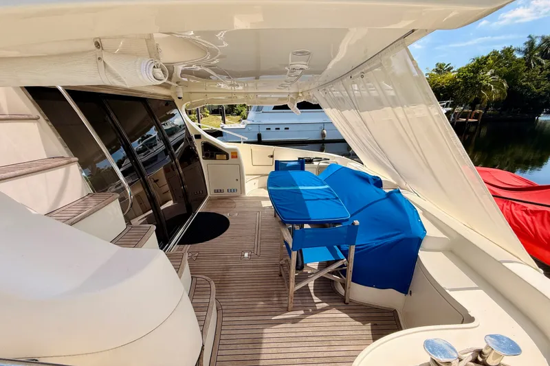 Slide: The Image of Luxurious 2008 Azimut 62 yacht deck with blue-covered seating and elegant wood flooring. - 12