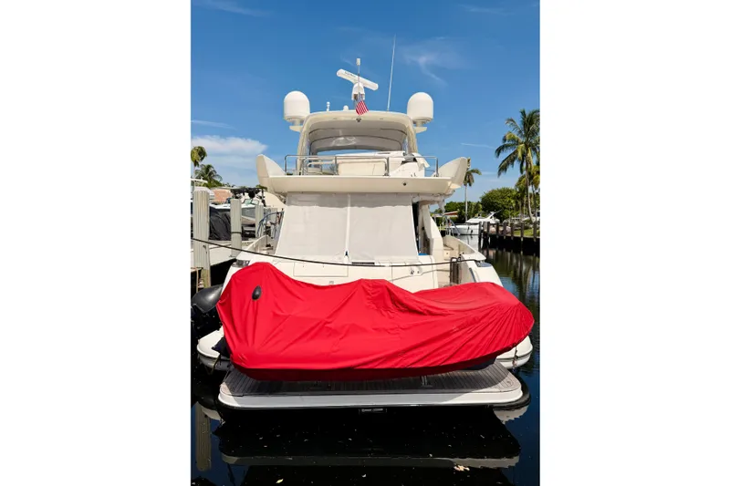 Slide: The Image of 2008 Azimut 62 yacht docked, featuring a red-covered jet ski on the deck. - 62