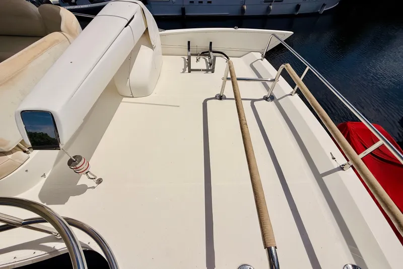 Slide: The Image of 2008 Azimut 62 yacht deck with seating and railing, docked by the water. - 3