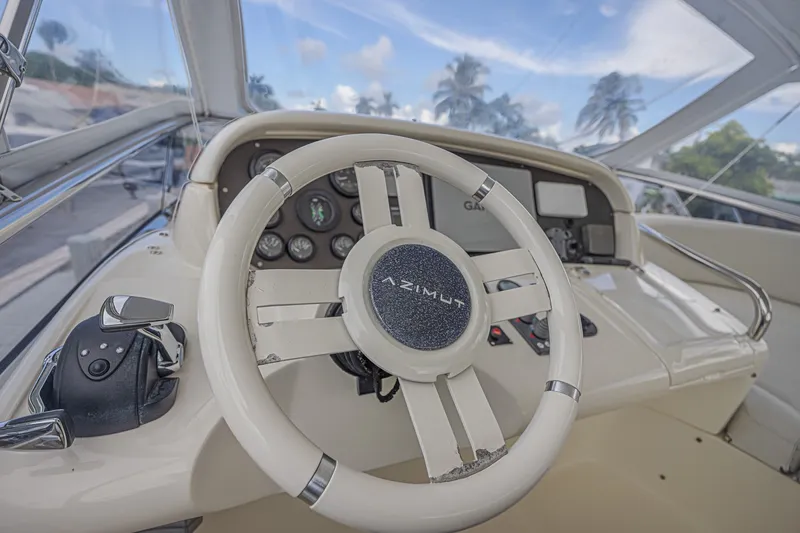 Slide: The Image of Steering wheel and dashboard of a 2008 Azimut 62 yacht, featuring navigation controls. - 10