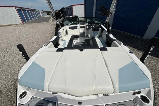 Slide: The Image of 2022 MasterCraft NXT22 boat with sleek interior design, parked outdoors. - 3
