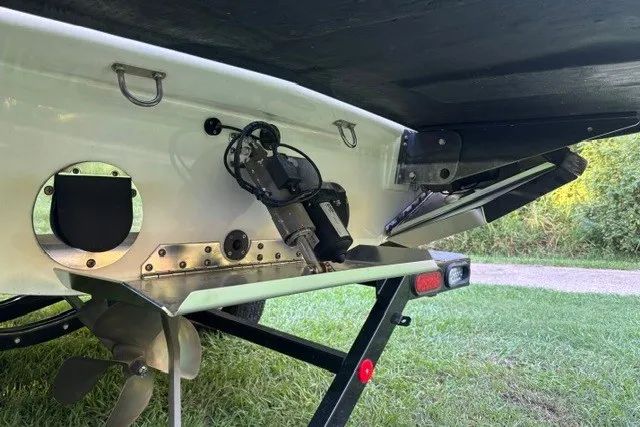 Slide: The Image of 2022 MasterCraft NXT22 boat underside showing propeller and trailer on grass. - 12