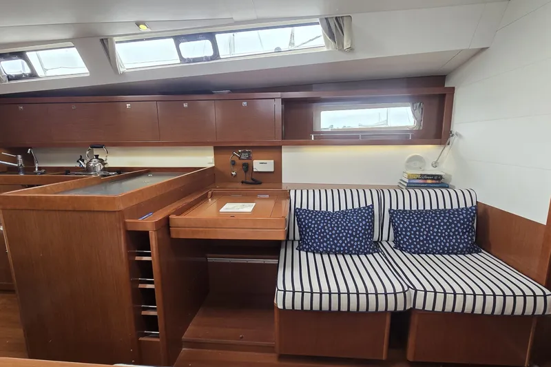 Slide: The Image of Interior of 2012 Beneteau Oceanis 45 yacht with striped seating and wooden cabinetry. - 17