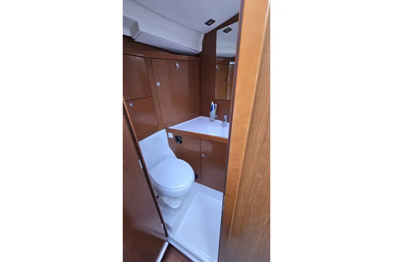 Slide: The Image of Beneteau Oceanis 45 (2012) yacht bathroom with wooden cabinetry and modern fixtures. - 19