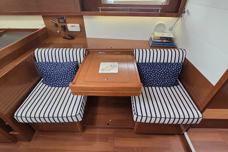 Slide: The Image of Interior of 2012 Beneteau Oceanis 45 yacht with striped seating and wooden table. - 16