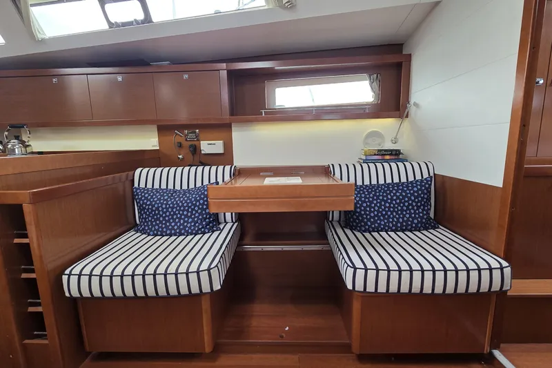 Slide: The Image of Interior of 2012 Beneteau Oceanis 45 yacht with striped seating and wooden cabinetry. - 15