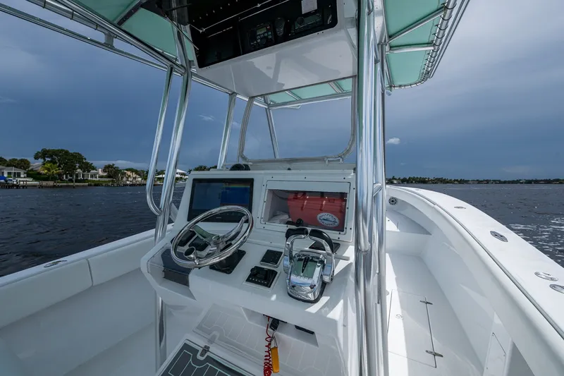 Slide: The Image of 1991 Jupiter 31 Center Console boat interior with steering wheel and controls on open water. - 24