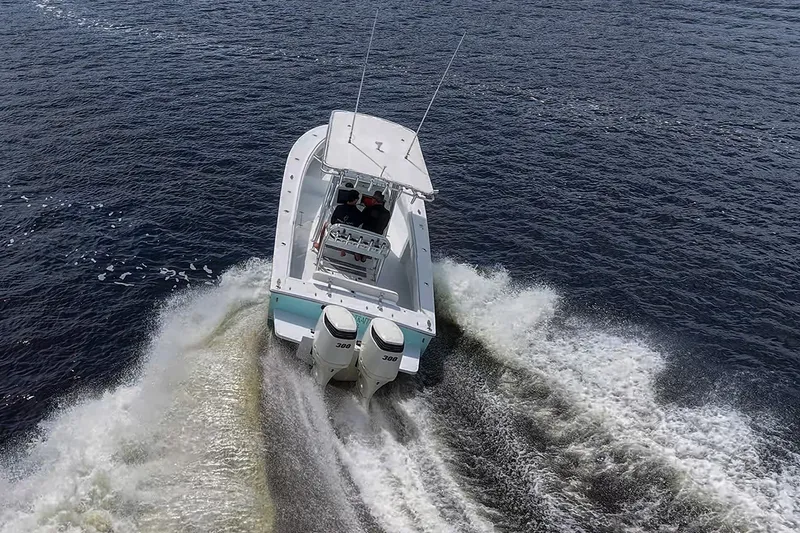 Slide: The Image of 1991 Jupiter 31 Center Console boat cruising on open water, rear view. - 21