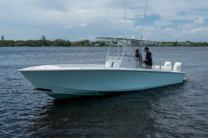 Slide: The Image of 1991 Jupiter 31 Center Console boat cruising on a calm lake under a clear sky. - 4
