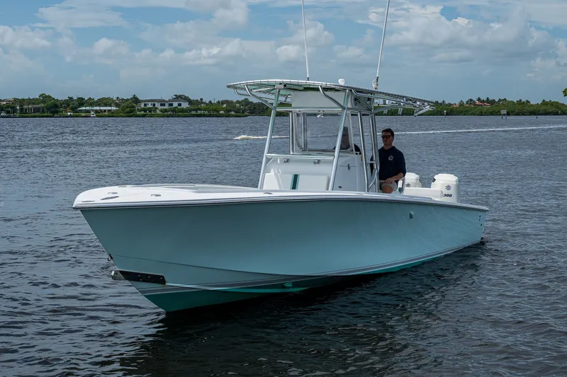 Slide: The Image of 1991 Jupiter 31 Center Console boat on calm water, with a person at the helm. - 5
