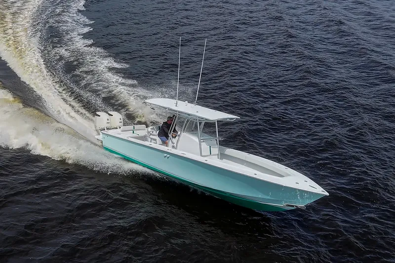 Slide: The Image of 1991 Jupiter 31 Center Console boat cruising on open water, creating a wake. - 18