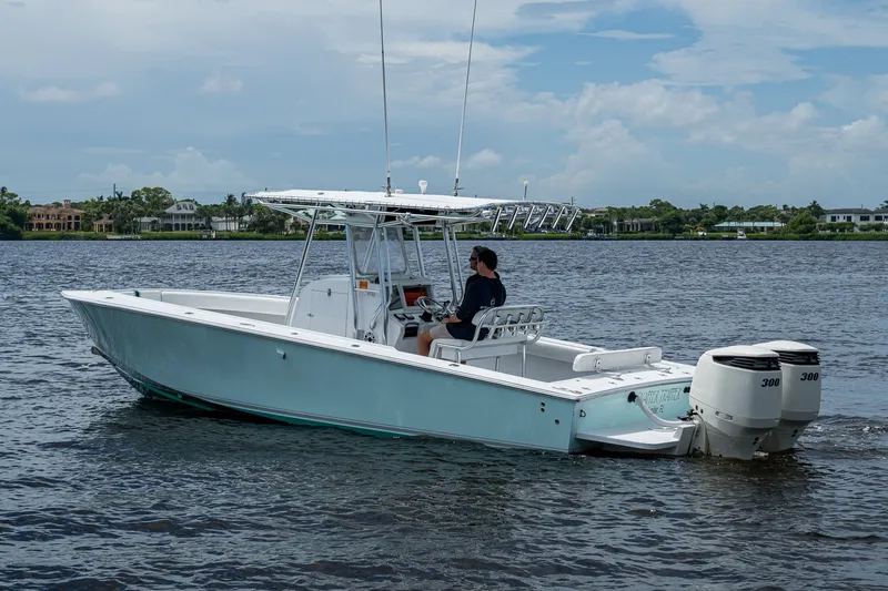 Slide: The Image of 1991 Jupiter 31 Center Console boat cruising on a calm lake under a cloudy sky. - 8