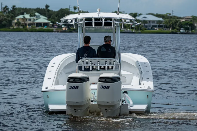 Slide: The Image of 1991 Jupiter 31 Center Console boat with dual 300 horsepower engines on a calm waterway. - 10