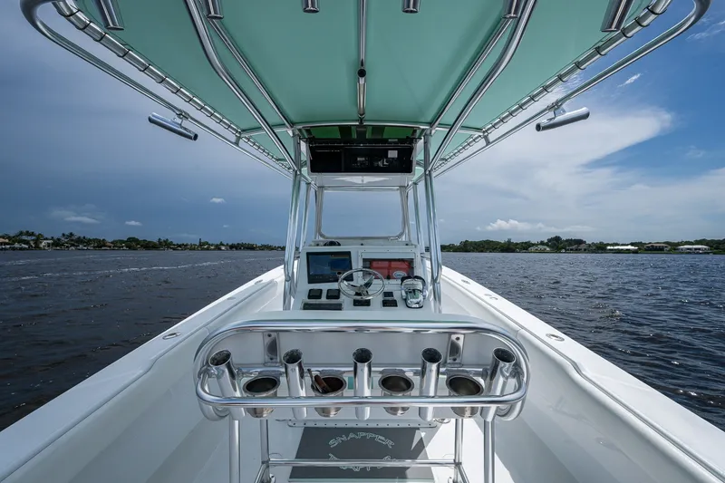 Slide: The Image of 1991 Jupiter 31 Center Console boat interior with steering wheel, rod holders, and ocean view. - 33