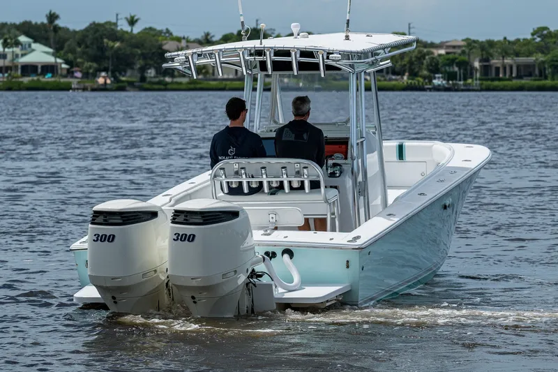 Slide: The Image of 1991 Jupiter 31 Center Console boat with dual 300 horsepower engines on a calm waterway. - 11