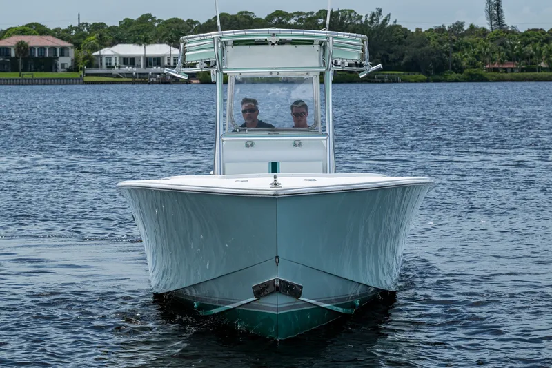 Slide: The Image of 1991 Jupiter 31 Center Console boat cruising on a calm lake with two passengers. - 3
