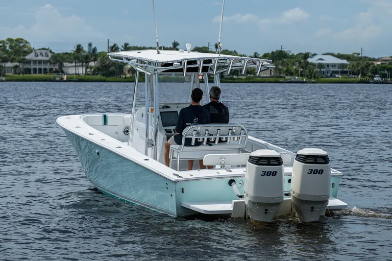 Slide: The Image of 1991 Jupiter 31 Center Console boat with dual 300 horsepower engines on a calm waterway. - 9