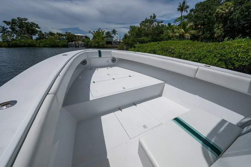 Slide: The Image of 1991 Jupiter 31 Center Console boat with spacious deck, surrounded by lush greenery. - 44