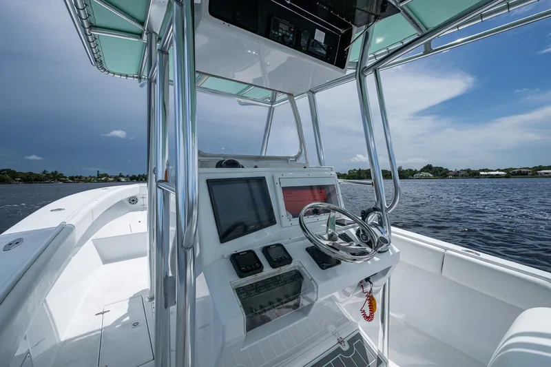 Slide: The Image of 1991 Jupiter 31 Center Console boat on water, featuring modern helm and controls. - 26